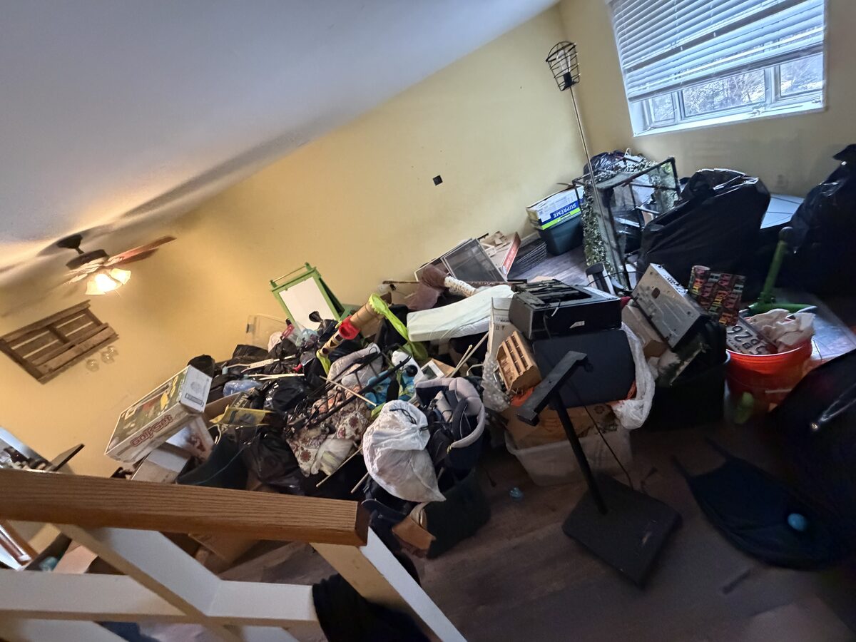 Room filled with clutter before house cleanout